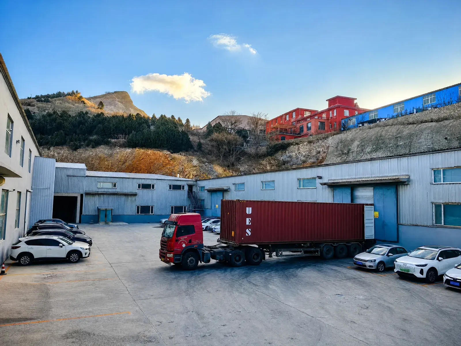 Illustrative container truck positioned at a factory loading area